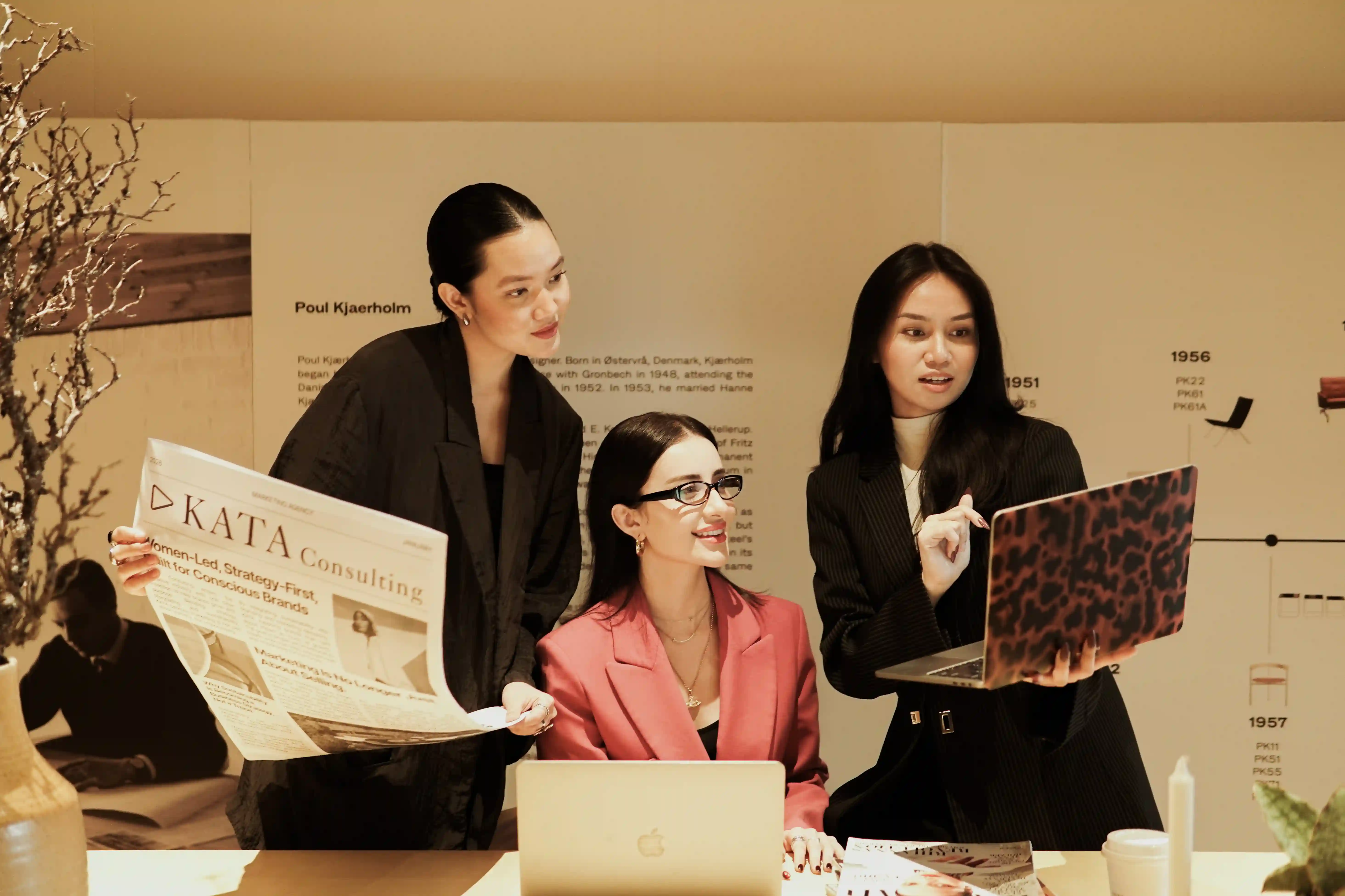 Three KATA team members holding laptops during the brand content shoot, close angle
